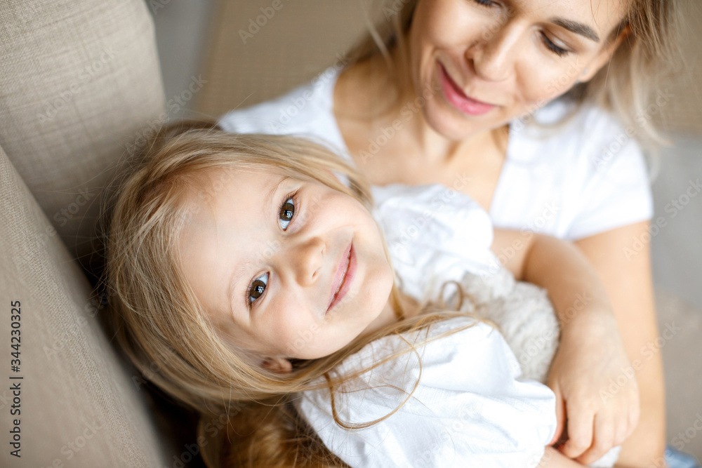 Mother's love. Mom hugs her little daughter. Maternal hugs. Female portraits close-up. The concept of female happiness