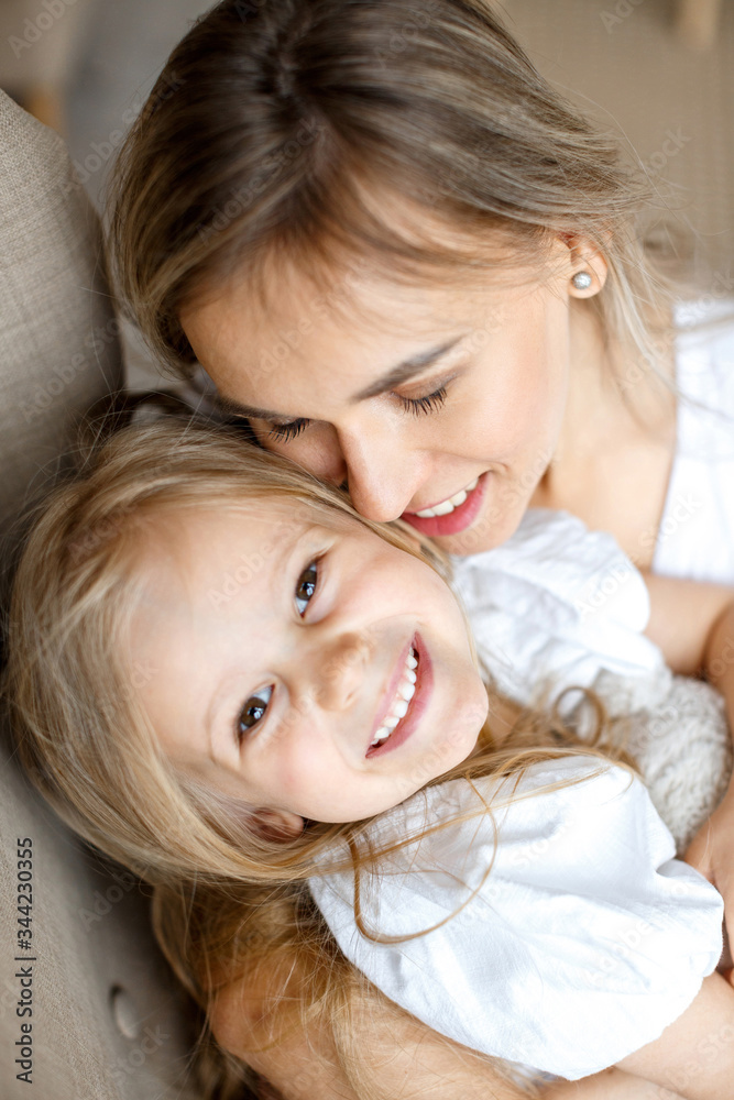 Mother's love. Mom hugs her little daughter. Maternal hugs. Female portraits close-up. The concept of female happiness