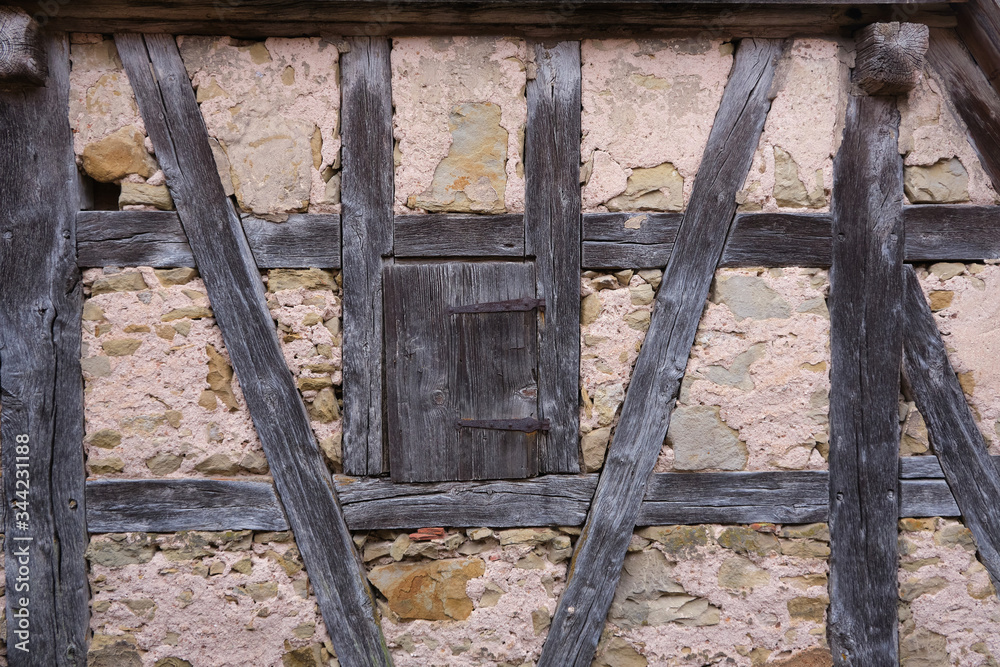 Half-timbered wall with closed hatch on an old house