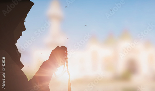 Photography Young female muslim prayer with hijab praying to God front of blur mosque background concept for eid mubarak, life and soul fasting of international islamic ramadan, Namaz