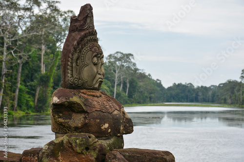 Statue of a demon (Buddhist asura) on a bridge over Siem Reap River near Bayon Temple. Angkor Thom, Cambodia