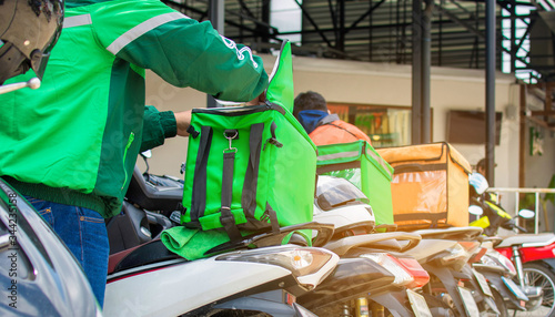 The food delivery driver is preparing the product to deliver to the customer according to the online order. Impact of epidemics