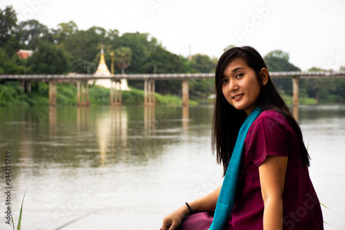 Travelers thai women alone wearing clothes mon ethnic style for take photo lonely at riverside of Mae Khlong or Meklong river at Ban Pong in evening in Ratchaburi, Thailand © tuayai