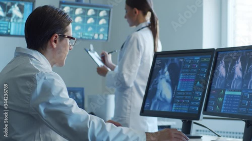 Medical doctors working in hospital office making computer research. Medicine, healthcare and technology concept.