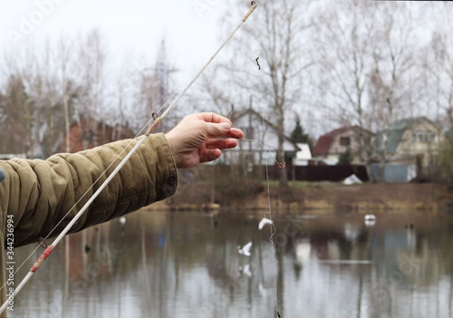 Fisherman is fishingon the pond. Fishing rod with a worm. photo