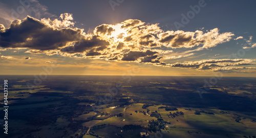 sunset behind clouds from sky over crop fields