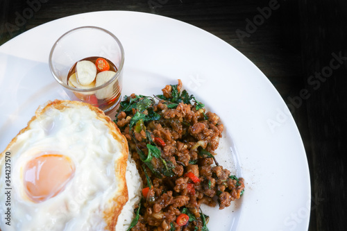 Thai stir-fried pork andfried egg and basil served with rice,Fried Basil with Pork Chop photo