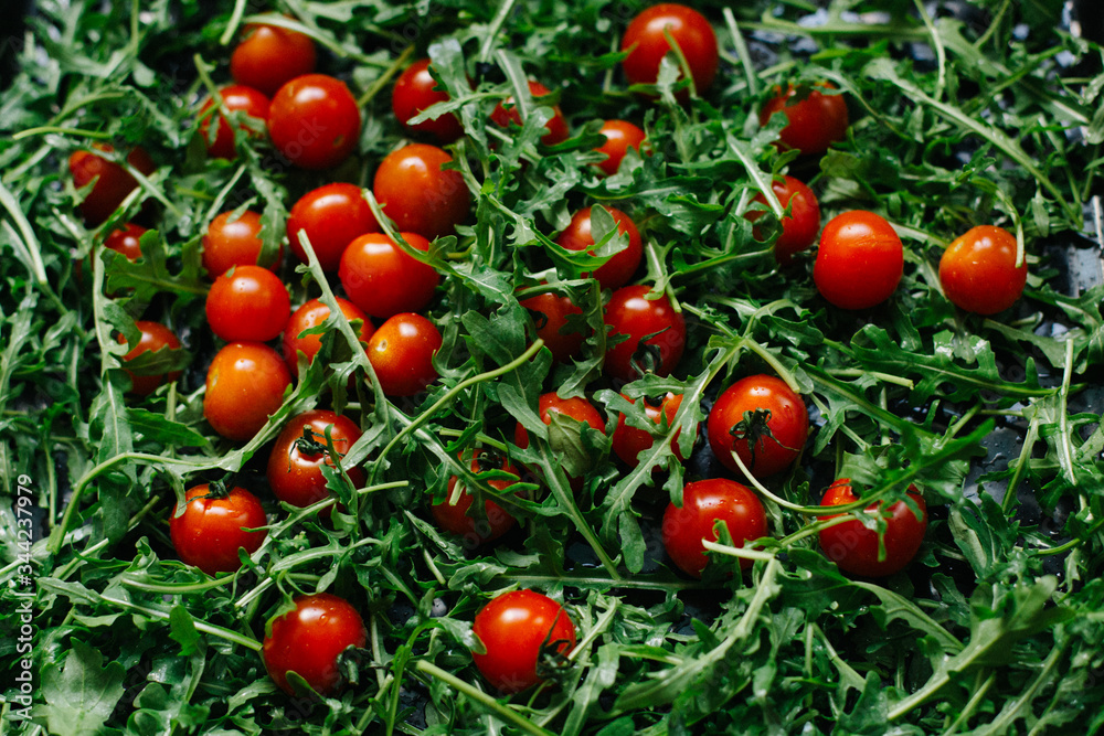 fresh small tomatoes on fresh arugula leaves