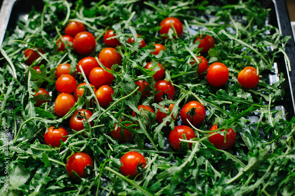 fresh small tomatoes on fresh arugula leaves