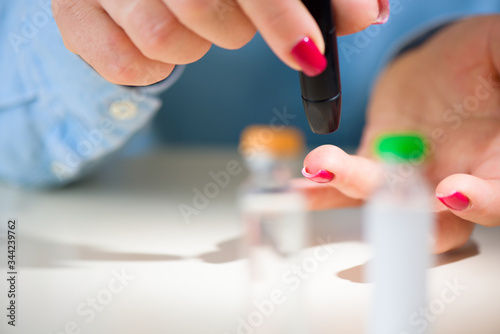 Examine sugar. Blocking sugar testing  woman finger lancet punctures. Close up.