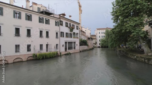 PAN SHOT - Colorful houses near the San Francesco bridge, crossing the Cagnan river, Treviso, Italy. photo