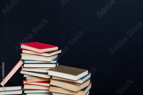 lots of stacks of educational books to teach at the college library on a black background