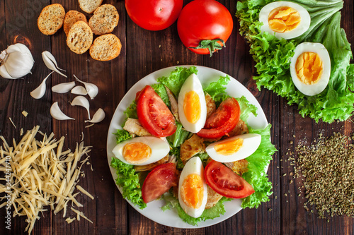 .Instructions for the preparation of Caesar salad. Step Five Cut the tomato into slices and add to the salad, laying next to the eggs.