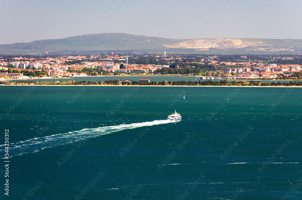 Ships and boats traversing the River Tagus beside the port of Lisbon in Portugal, Europe