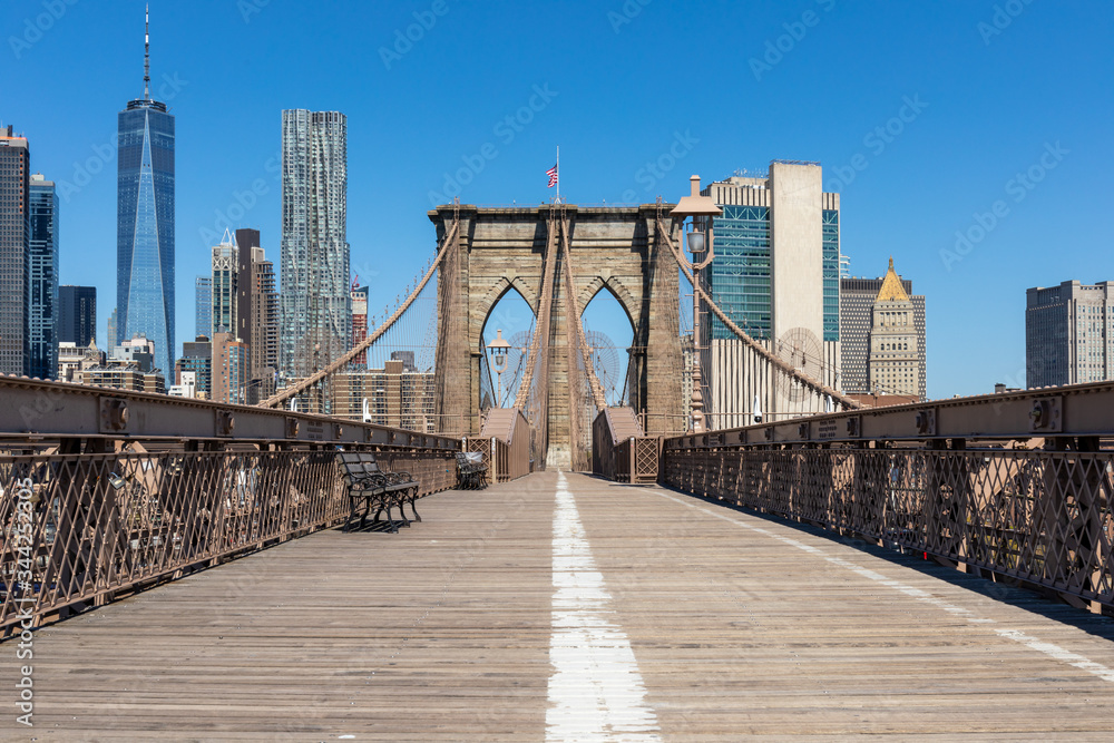 Fototapeta premium Widok na dolny Manhattan z pustego chodnika dla pieszych na moście Brooklyn w Nowym Jorku.