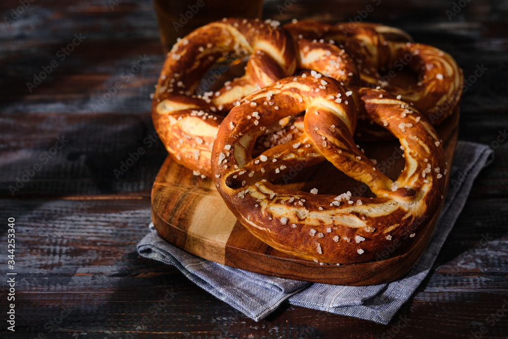 Freshly baked homemade soft pretzel with salt on wooden table. Perfect for Octoberfest. Freshly baked homemade soft pretzel with salt on wooden table. Perfect for Octoberfest.