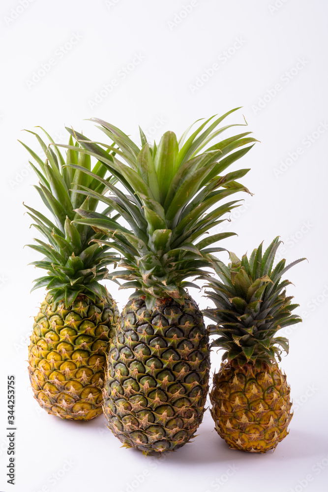 Ripe Pineapples Of Different Sizes Against White Background