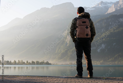 Man standing at the edge of the beautiful lake brienz on a fall morning in switzerland
