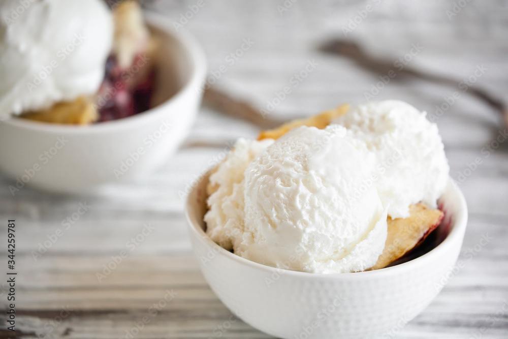 Fresh made homemade cherry cobbler served with two scoops of vanilla ice cream. Selective focus with blurred background. Fresh made homemade cherry cobbler served with two scoops of vanilla ice cream. Selective focus with blurred background.