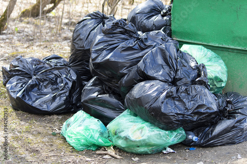 Black and green garbage bags filled with garbage. Save the planet concept.
