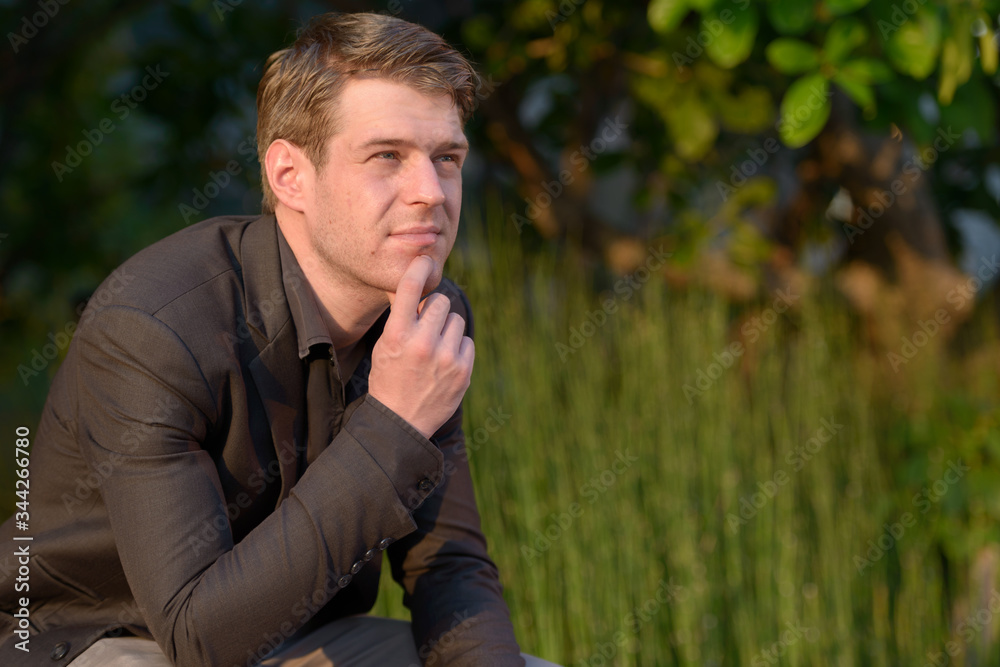 Young handsome businessman in suit thinking in nature outdoors Young handsome businessman in suit thinking in nature outdoors