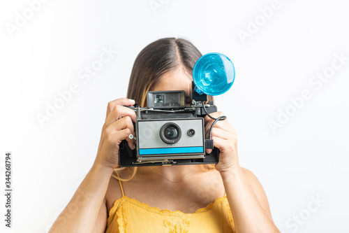 Obraz na płótnie Girl holding vintage instant camera w salonie