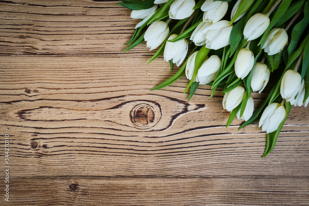Top view of spring flowers tulips on a old vintage brown wooden background. Top view of spring flowers tulips on a old vintage brown wooden background.