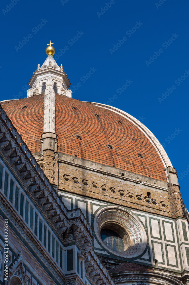 The dome and cross of the Basilica di Santa Maria del Fiore (Basilica of Saint Mary of the Flower). View from Giotto's Campanile. Florence, Tuscany, Italy.