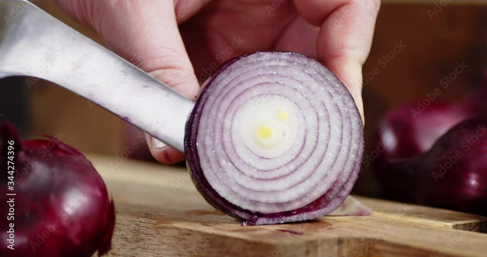 Hands men cut red onion in rings.