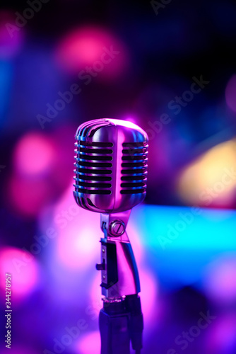 Karaoke background.Silver vintage microphone on bokeh.Close-up of retro microphone at concert.Professional microphone
