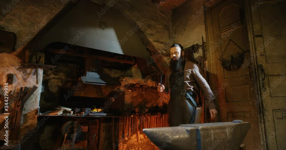 custom made wallpaper toronto digitalCaucasian handsome smith with long beard working in antique smithy. Brutal man choosing equipment for work in rural forge. Old styled metal industry.