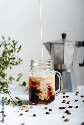 Pouring milk into iced coffee