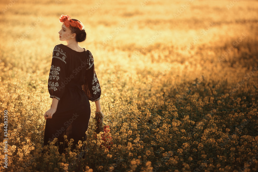 Young woman with wreath and bouquet of poppies in the field Young woman with wreath and bouquet of poppies in the field