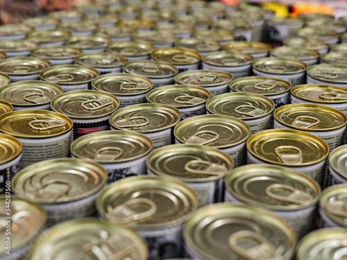 Iron cans with canned goods in a store on the counter. A lot of goods in the supermarket