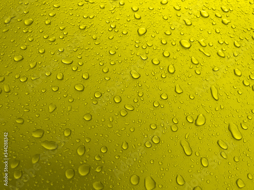 Drops of water on a yellow metal surface  beautiful background after rain