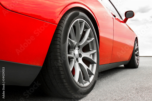 Red car. Car wheels close up on a background of asphalt. Car tires. Car wheel close-up. for advertising. © Stasiuk