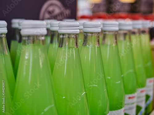 Bottled lemonade on shelves in a supermarket. A lot of bottles