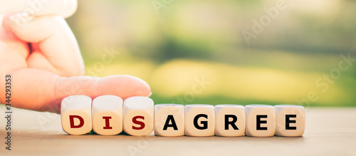 Photos Hand turns dice and changes the expression disagree to agree.