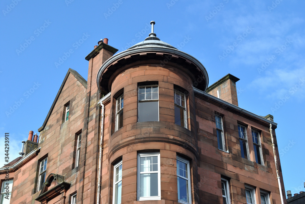 Circular Corner Tower on Stone Victorian Building seen from Below against Blue Sky 