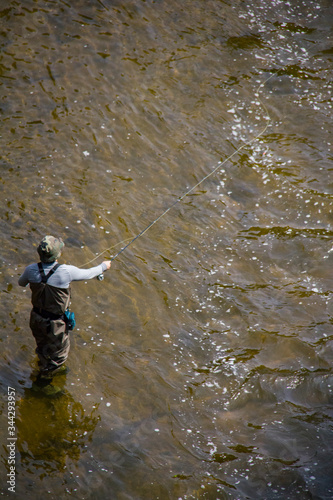 Fly fisherman standing in the water as seen from above.