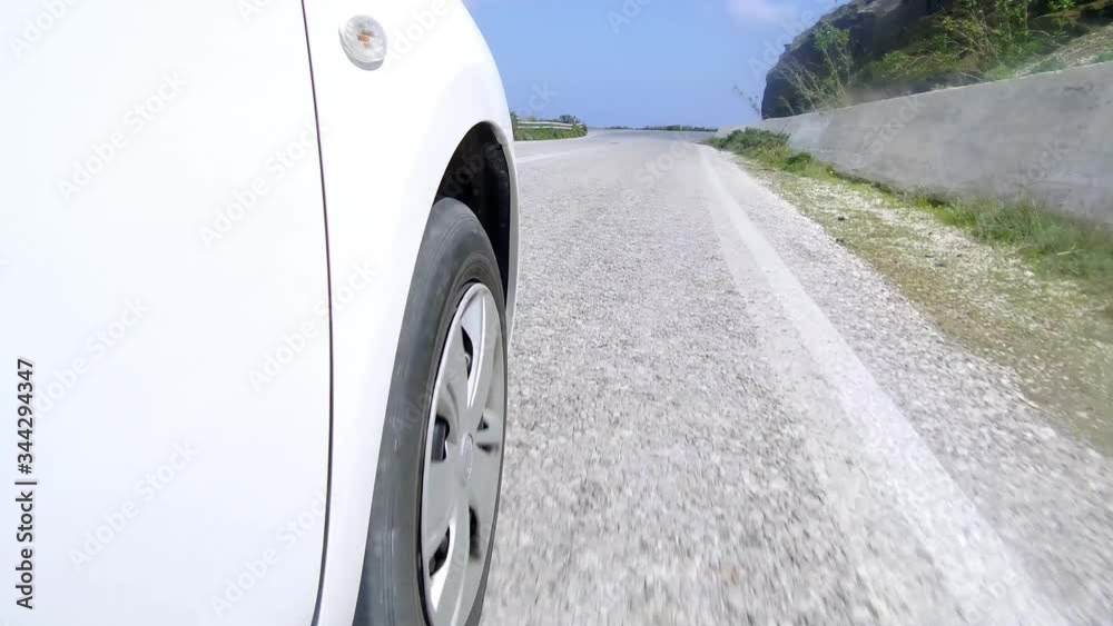 Low angel car driving wheel rolling pov close up on a mountain road mounted camera Low angel car driving wheel rolling pov close up on a mountain road mounted camera