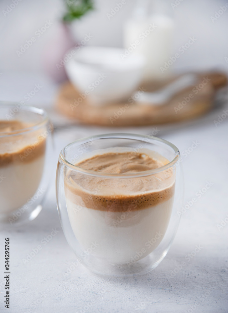 Korean dalgona coffee in a glass Cup with soy milk on light background. Trendy and vegan drink Korean dalgona coffee in a glass Cup with soy milk on light background. Trendy and vegan drink