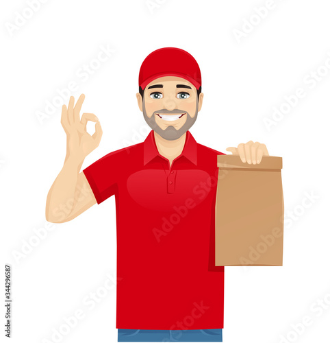 Handsome delivery man in red uniform gesturing ok sign with paper packet isolated vector illustration