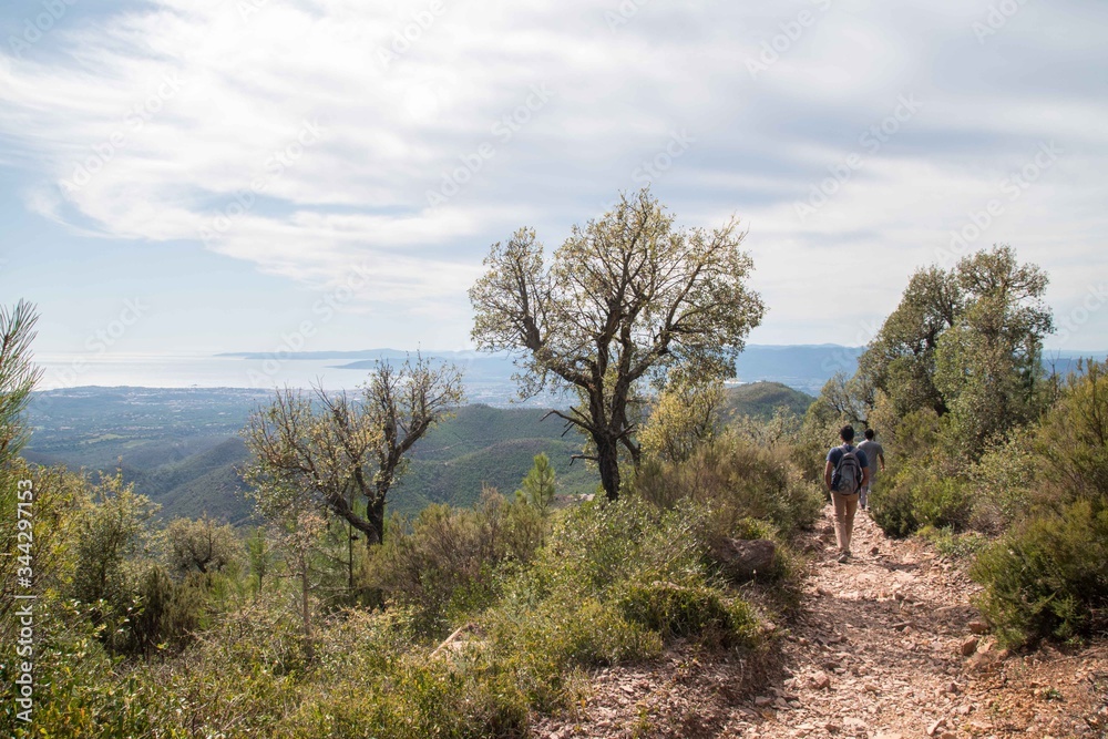 Hiker walking down a rocky trail in the hills in Cannes district