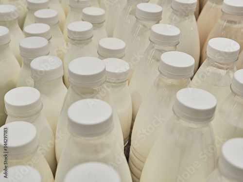 Bottled milk on a shelf in a supermarket. Many bottles