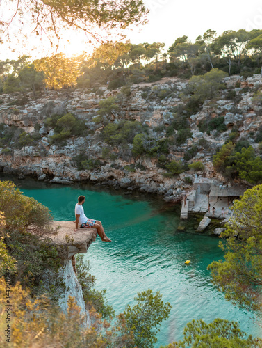 Young male at beautiful Cala Pi, Majorca with turquoise water at sunset