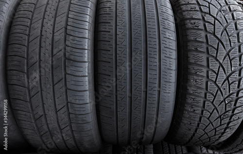 a row of used tires with three different tread types, left to right, directional asymmetrical for all weather, symmetrical mostly for passenger cars, and asymmetrical mostly for sports cars. 