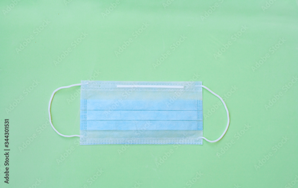 Medical mask on a green background. Concept of medicine, protection from infection, protection from coronavirus, stop coronavirus, end of the pandemic Medical mask on a green background. Concept of medicine, protection from infection, protection from coronavirus, stop coronavirus, end of the pandemic