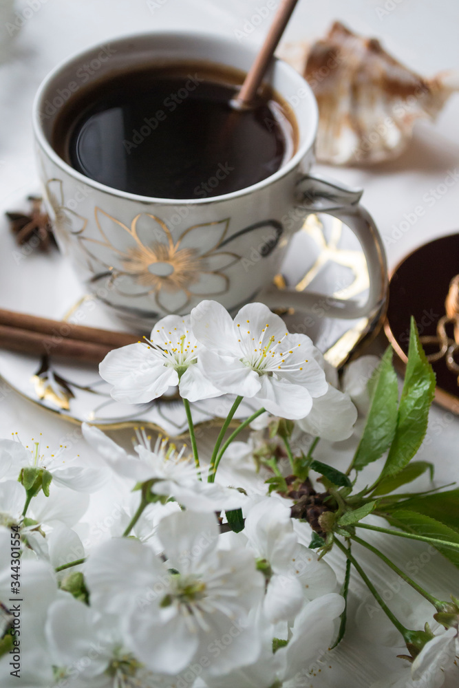 A cup of coffee and blossom branches. Spring morning. A cup of coffee and blossom branches. Spring morning.