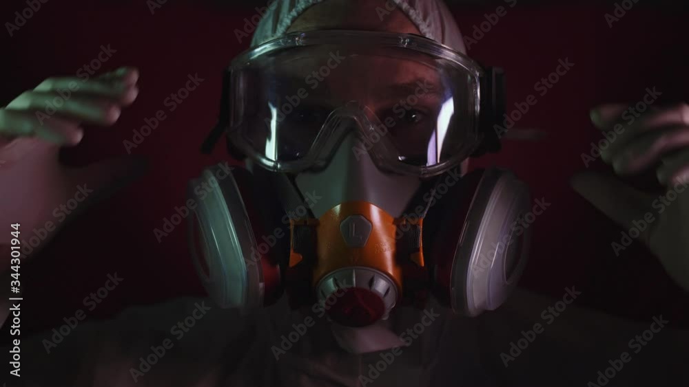 Man in protective costume suit, gas protect medical antibacterial antiviral spray paint mask. Doctor health worker in respirator. Concept health virus coronavirus epidemic. Radiation Nuclear war.